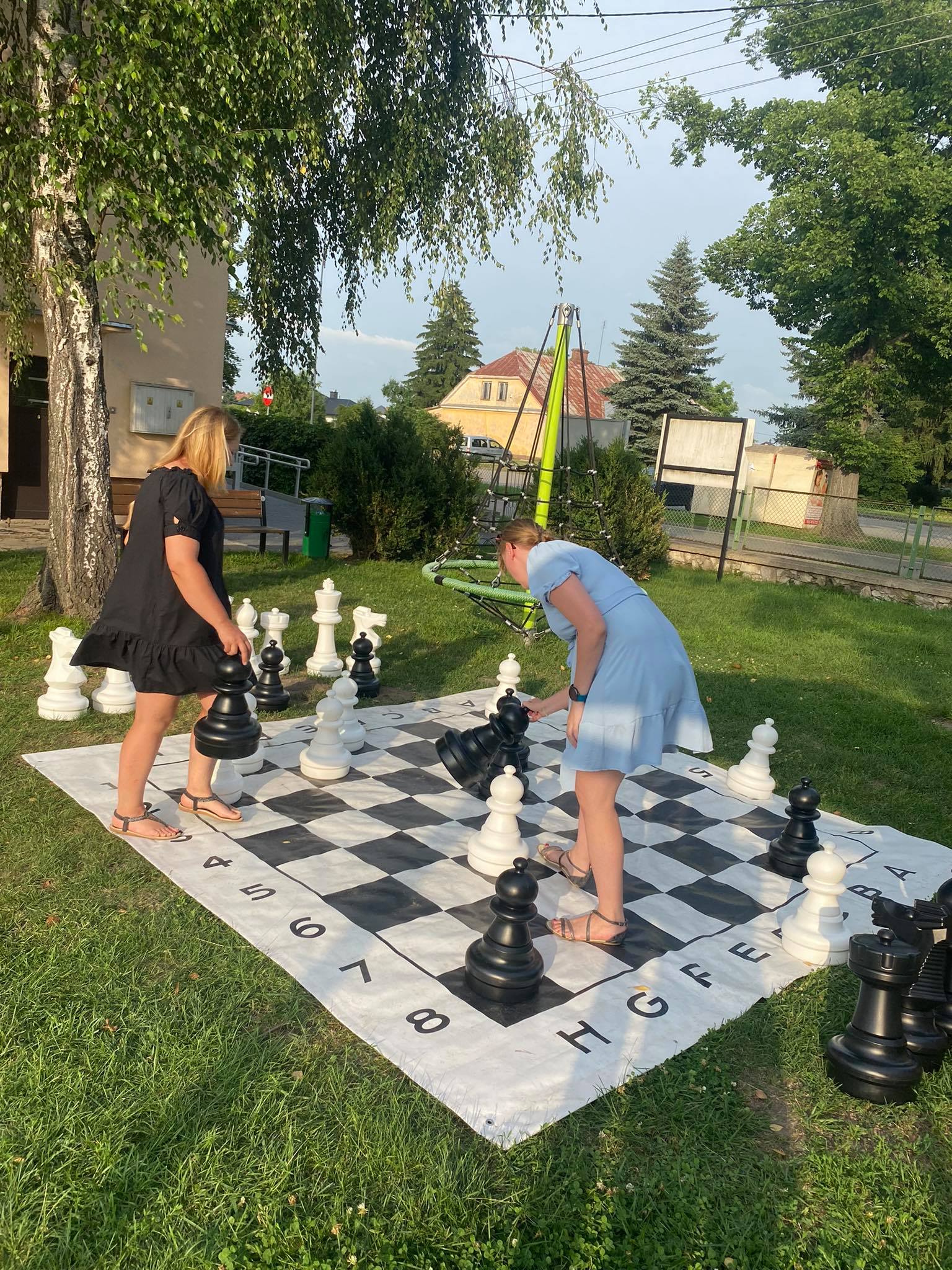 Zdjęcie przedstawia naukę gry w szachy.