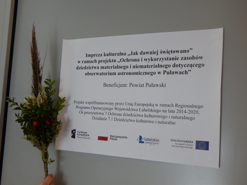 Tablica opisująca wydarzenie „Jak dawniej świętowano” w ramach projektu „Ochrona i wykorzystanie zasobów dziedzictwa materialnego i niematerialnego dotyczącego obserwatorium astronomicznego w Puławach”.