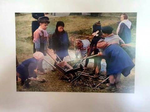 Zdjęcie przedstawia przedszkolaki pomagające przy pracach ogrodowych.
