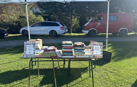 Zdjęcie prezentuje stoisko bookcrossing przygotowane przez Powiatową Bibliotekę Publiczną w Puławach wystawione podczas XIV Turniej Piłki Nożnej Samorządowców Powiatu Puławskiego im. Mariusza Próchniaka. 