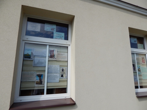Zdjęcie prezentuje wystawę na oknach Powiatowej Biblioteki Publicznej w Puławach pt. „Książki z latem w tle”.