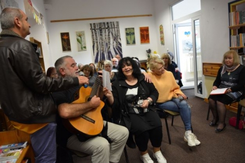 Zdjęcie prezentuje spotkanie poetycko – muzyczne Międzynarodowej Grupy Artystycznej „Pod wiatr”, które odbyło się w Bibliotece Publicznej w Kazimierzu Dolnym. 