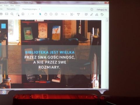 Zdjęcie przedstawiające ekran komputera, na którym widnej slajd z sentencją: Biblioteka jest wielka przez swą gościnność a nie przez swe rozmiary. 