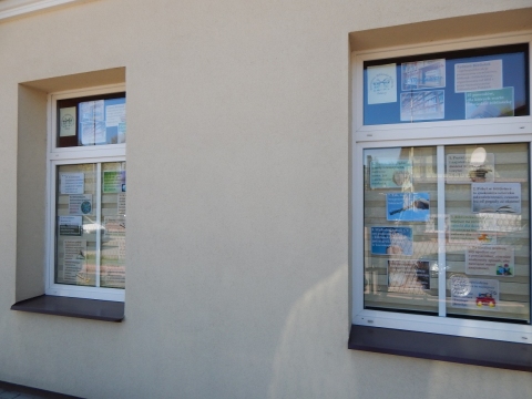 Wystawa na oknach biblioteki prezentująca 25 powodów dla których warto odwiedzić bibliotekę