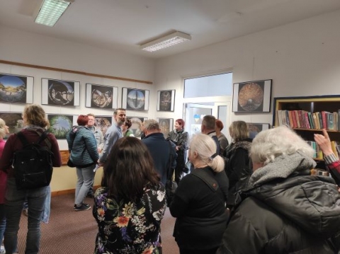 Zdjęcie prezentuje wernisaż wystawy Grzegorza Pawlaka w Bibliotece Publicznej w Kazimierzu Dolnym.