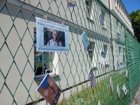 Zdjęcie przedstawia wystawę okładek książkę Stanisława Lema, które zawisły na płocie przed PBP w Puławach. 