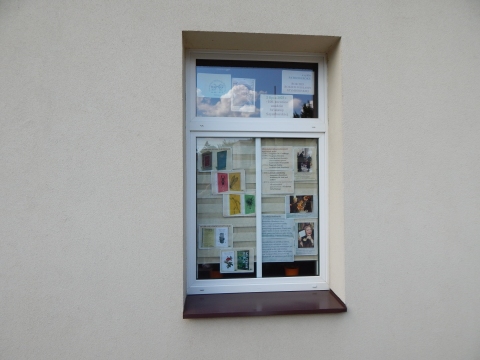 Zdjęcie prezentuje wystawę na oknach Powiatowej Biblioteki Publicznej w Puławach pokazującą życie i twórczość Wisławy Szymborskiej. 