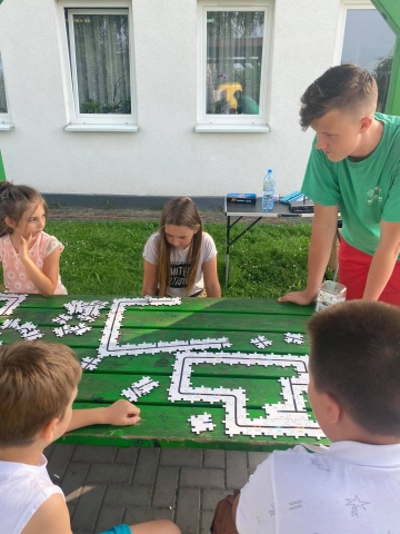 Zdjęcie przedstawia dzieci układające puzzle. 