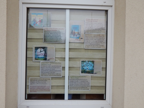 Zdjęcie prezentuje wystawę na oknach Powiatowej Biblioteki Publicznej w Puławach pt. „Literackie życzenia dla babci i dziadka”.