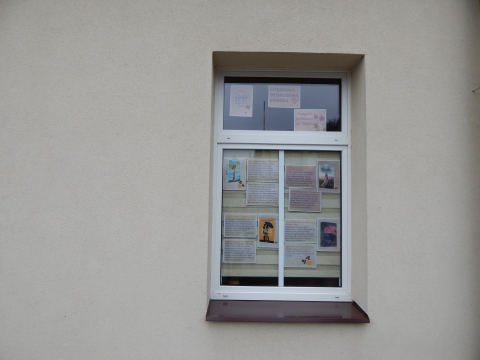  Zdjęcie prezentuje wystawę na oknach Powiatowej Biblioteki Publicznej w Puławach promującą  jesienne propozycje książkowe z wyrazem „deszcz” w tytule.