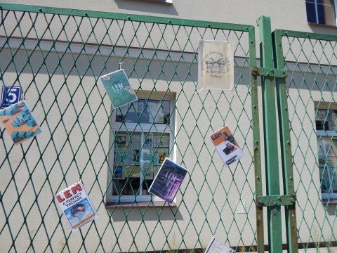 Zdjęcie przedstawia wystawę okładek książkę Stanisława Lema, które zawisły na płocie przed PBP w Puławach. 