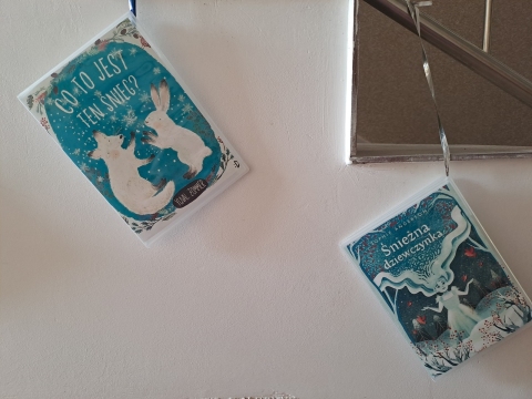 Zdjęcie prezentuje wystawę na oknach Powiatowej Biblioteki Publicznej, która promuje książki, których akcja rozgrywa się w zimowej scenerii.