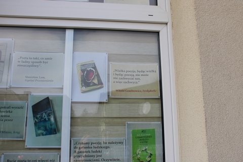 Zdjęcie prezentuje wystawę na oknach Powiatowej Biblioteki Publicznej w Puławach prezentującą cytaty z różnych książek, które próbują zdefiniować czym jest poezja i kto to jest poeta.
