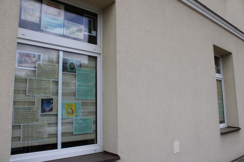 Zdjęcie prezentuje wystawę na oknach Powiatowej Biblioteki Publicznej pokazującą książki dla dzieci, których akcja rozgrywa się właśnie w bibliotece. 