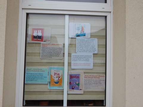 Zdjęcie prezentuje wystawę na oknach Powiatowej Biblioteki Publicznej w Puławach pt. „Literackie życzenia dla babci i dziadka”.