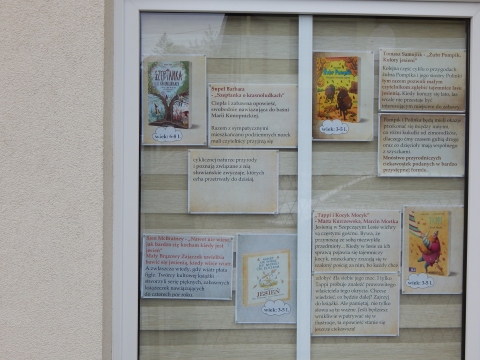 Zdjęcie prezentuje wystawę na oknach Powiatowej Biblioteki Publicznej w Puławach prezentującą książki dla dzieci, których akcja rozgrywa się w jesiennej scenerii.