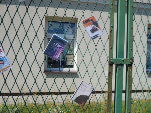 Zdjęcie przedstawia wystawę okładek książkę Stanisława Lema, które zawisły na płocie przed PBP w Puławach. 