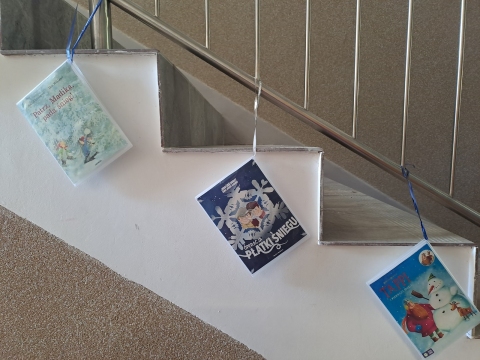 Zdjęcie prezentuje wystawę na oknach Powiatowej Biblioteki Publicznej, która promuje książki, których akcja rozgrywa się w zimowej scenerii.
