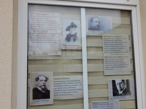 Zdjęcie prezentuje wystawę na oknach Powiatowej Biblioteki Publicznej w Puławach pt. „Ciekawostki z życia pisarzy”.