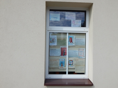 Zdjęcie prezentuje wystawę na oknach Powiatowej Biblioteki Publicznej w Puławach pokazującą różne publikacje mam i macierzyństwa. 