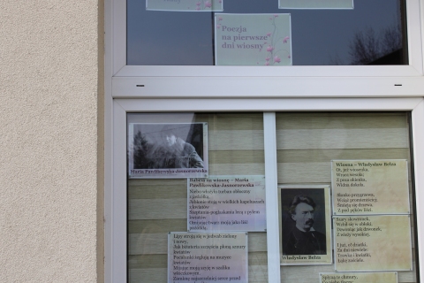 Zdjęcie prezentuje wystawę na oknach Powiatowej Biblioteki Publicznej w Puławach, prezentującą wiersze polskich poetów opisujące wiosnę oraz jej charakterystyczne motywy.