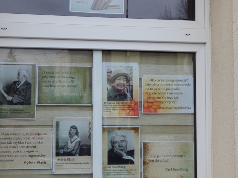 Zdjęcie prezentuje wystawę na oknach Powiatowej Biblioteki Publicznej w Puławach pokazującą różne definicje słowa poezja. 