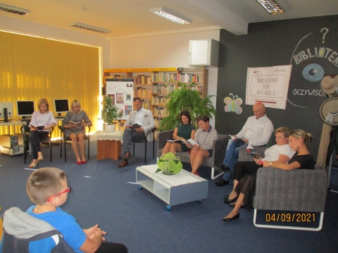 Zdjęcie prezentuje osoby czytające fragmenty dramatu "Moralność Pani Dulskiej" Gabrieli Zapolskiej w siedzibie biblioteki.
