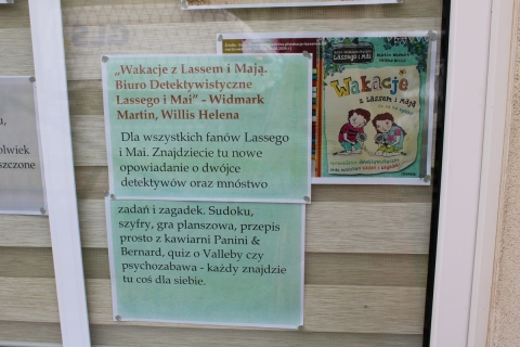 Zdjęcie prezentuje wystawę na oknach Powiatowej Biblioteki Publicznej prezentującą letnie propozycje czytelnicze dla najmłodszych.