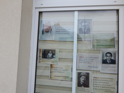Zdjęcie prezentuje wystawę na oknach Powiatowej Biblioteki Publicznej w Puławach pokazującą różne definicje słowa poezja. 