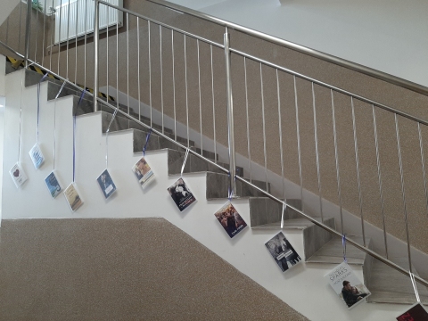 Zdjęcie prezentuje wystawę powieszoną na korytarzu przed biblioteką prezentującą różne okładki książek, których głównym tematem jest miłość. 