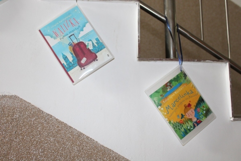 Zdjęcie prezentuje wystawę na korytarzu przed Powiatową Biblioteką Publiczną prezentującą letnie propozycje czytelnicze dla najmłodszych.