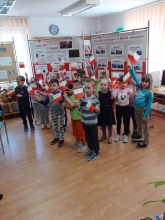 Zdjęcie prezentuje lekcję biblioteczną w Gminnej Bibliotece Publicznej w Wąwolnicy dotyczącą symboli narodowych Rzeczypospolitej Polskiej. Dzieci wykonują flagę. 