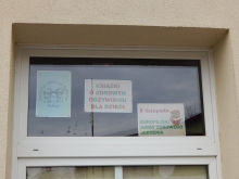 Zdjęcie prezentuje wystawę na oknach Powiatowej Biblioteki Publicznej w Puławach pokazującą książki promujące zdrowe odżywanie wśród najmłodszych. 