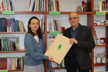 Zdjęcie prezentuje pana Zbigniewa Pieleszka puławskiego artystę plastyka, który przekazuje na ręce pani dyrektor Powiatowej Biblioteki Publicznej niezwykły prezent - dwa linoryty. 