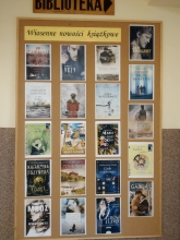 Zdjęcie prezentuje wystawę pt. Wiosenne nowości książkowe znajdującą się na korytarzu przed wejściem do Gminnej Biblioteki Publicznej w Baranowie.
