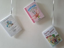 Zdjęcie prezentuje wystawę powieszoną na korytarzu przed biblioteką prezentującą różne okładki książek dla dzieci, w tytule których pojawia się wyraz szkoła. 