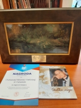 Zdjęcie prezentuje egzemplarz książki Zbigniewa Kozaka pt. „Godko moja”, dyplom i obraz jako nagrody w Powiatowym konkursie wydawnictw. 